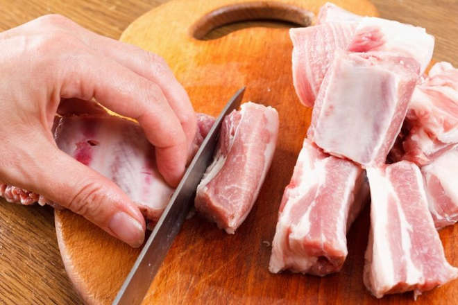 Повар режет мясо